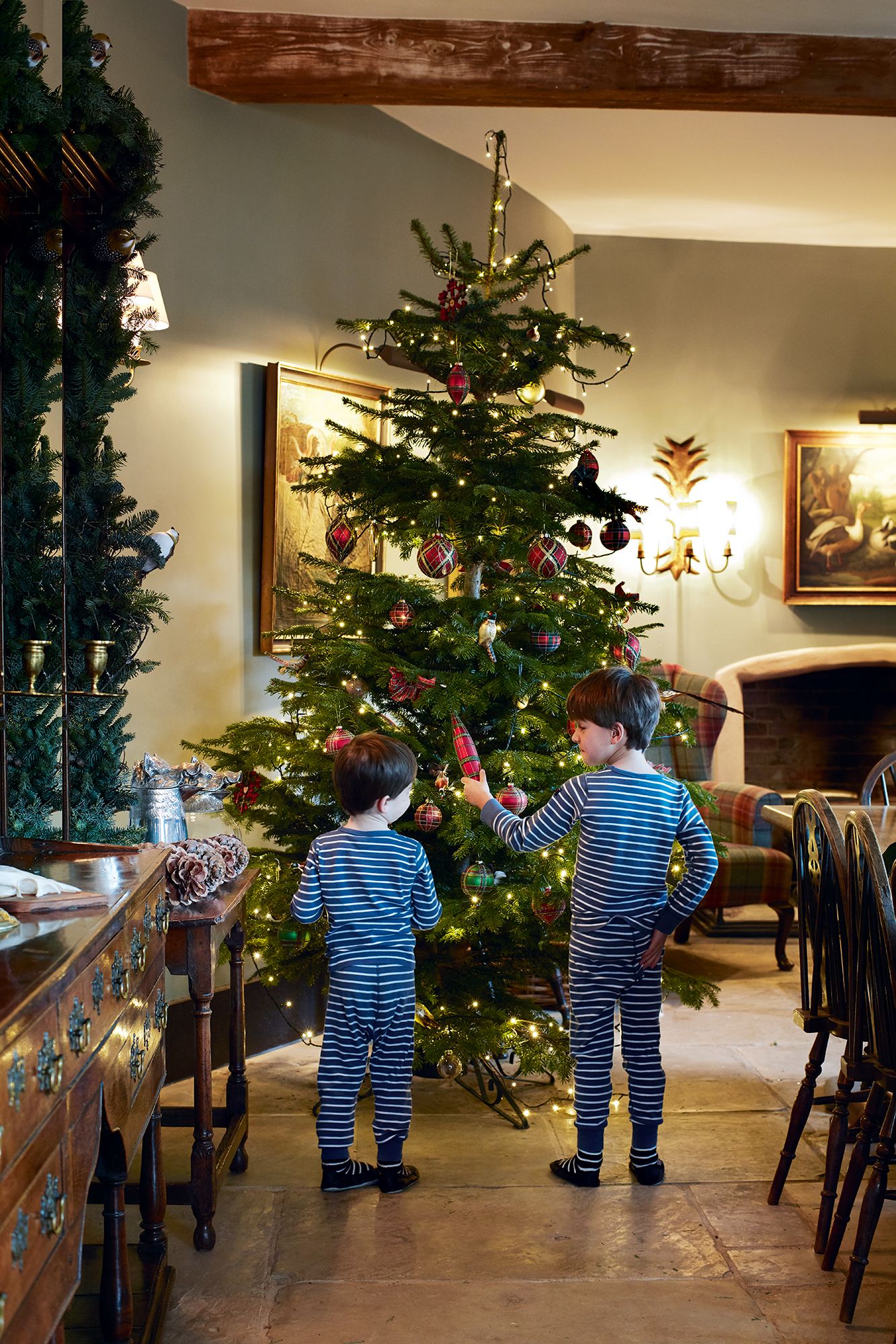Tartan bows and baubles adorn one of the trees in the family home of Chelsea Textiles founder Mona Perlhagen