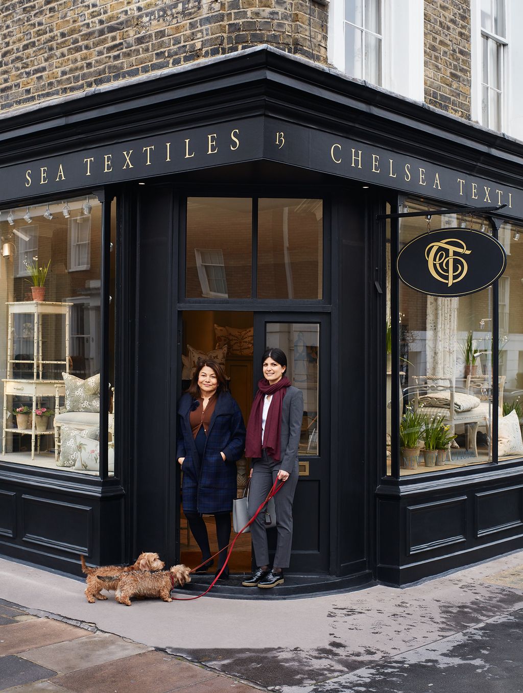 Mona and Jenny outside their second shop in Walton Street SW3 with Jennys dachshunds.