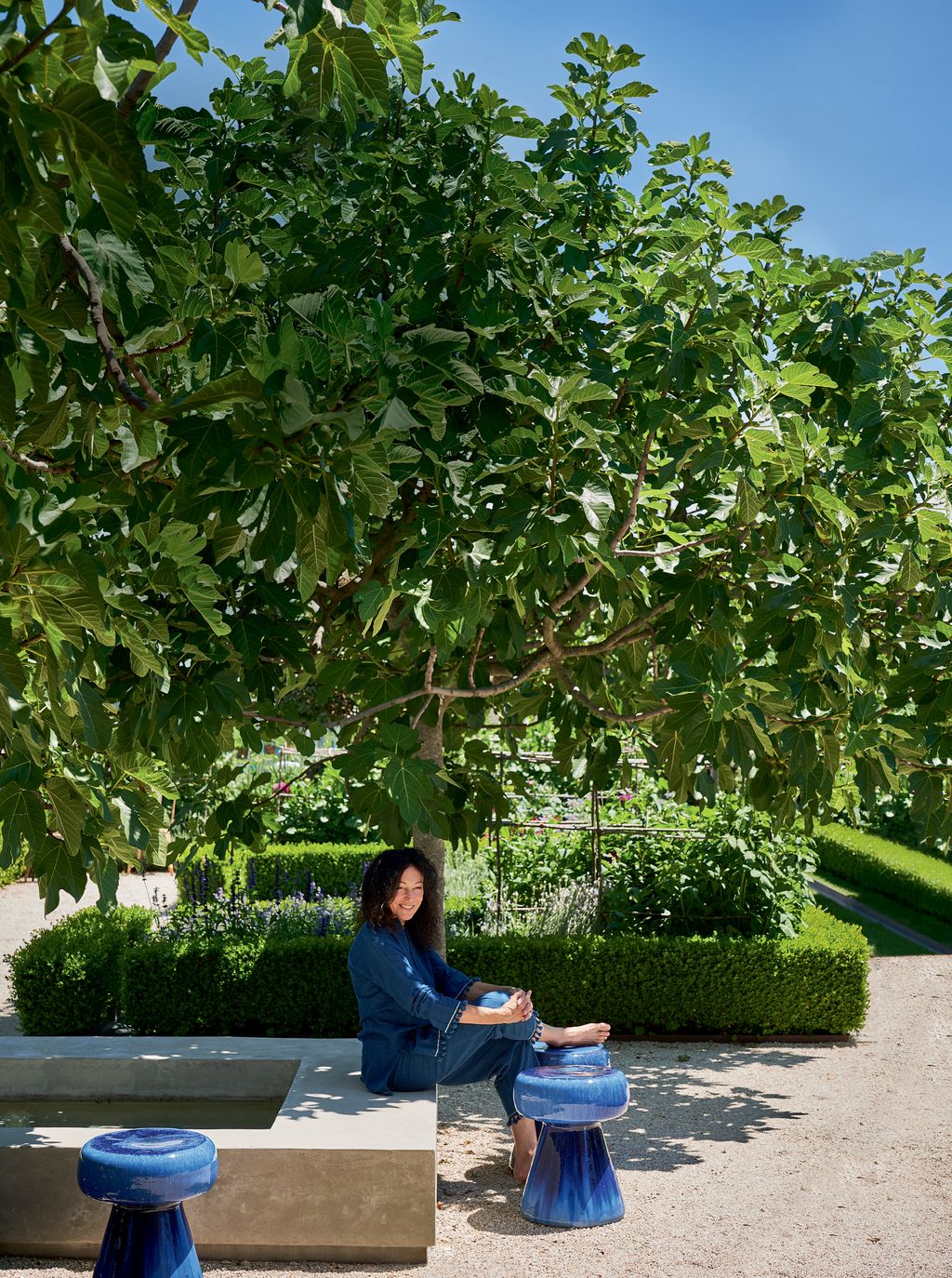 Tricia in the kitchen garden the heart of the property where vegetables and flowers abound. Paola Navones blue ceramic...
