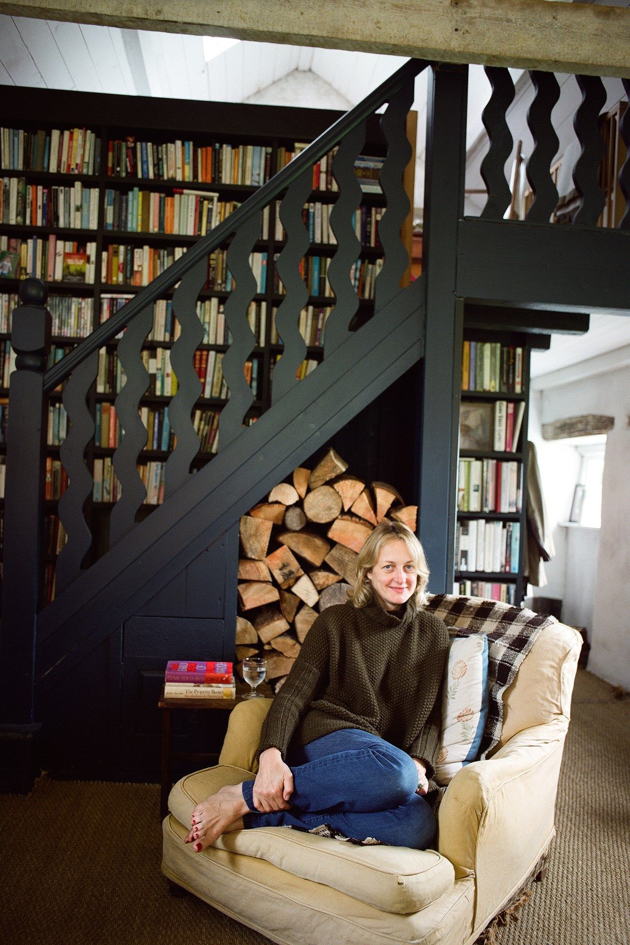 Image may contain Furniture Couch Human Person Room Indoors Living Room Shelf Bookcase Banister and Handrail