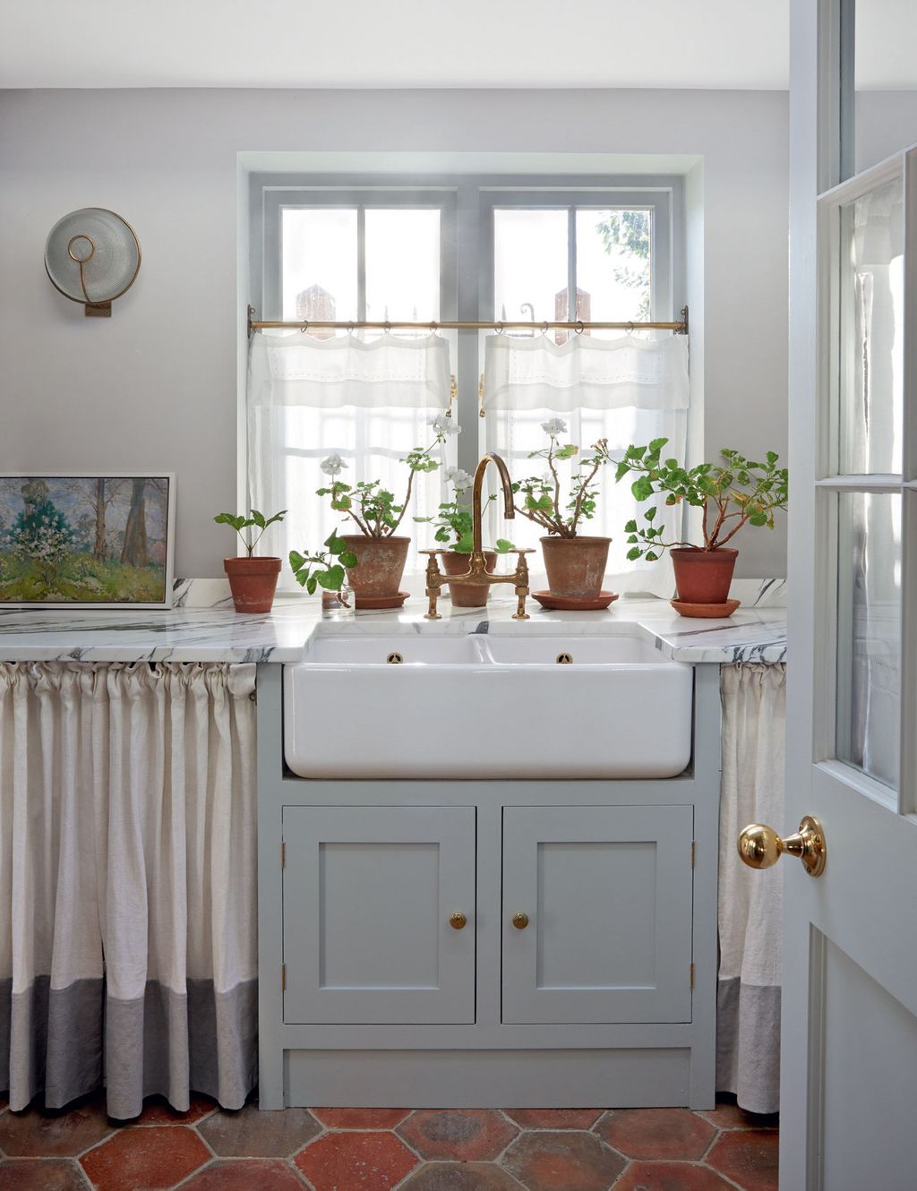 A double Belfast sink and marble worktops are practical choices for this hardworking space.