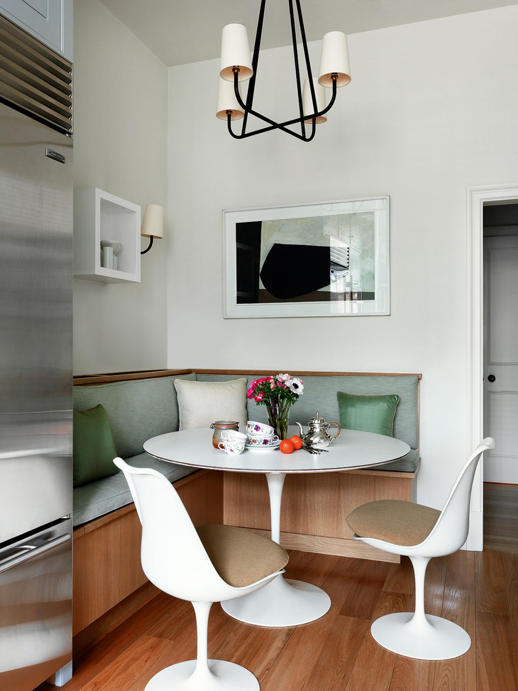 A vintage Jean Royère pendant light from Christopher Howe hangs above the Eero Saarinen ‘Tulip table. French company...