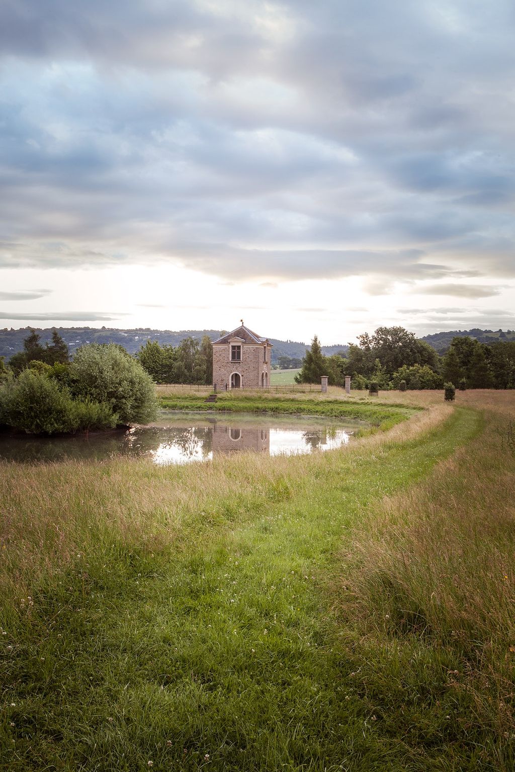 A tower designed by architect Craig Hamilton reflected in the small lake.