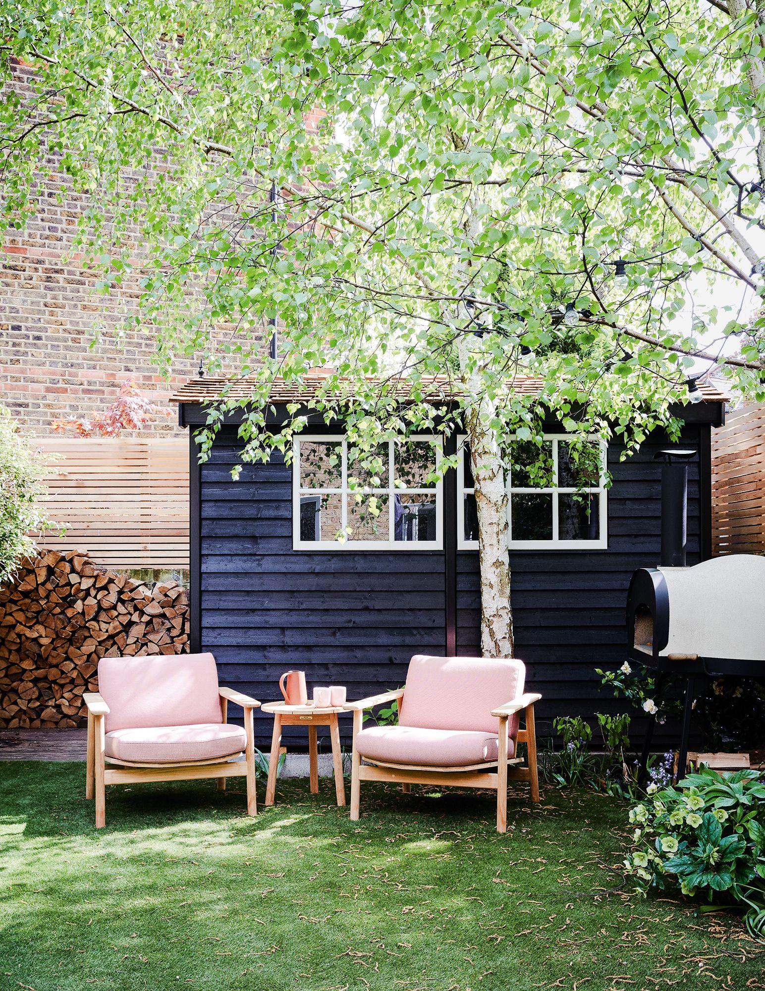 Suzy Hoodless' lowmaintenance garden features a smart black shed with overlapping cladding and whiteframed windows