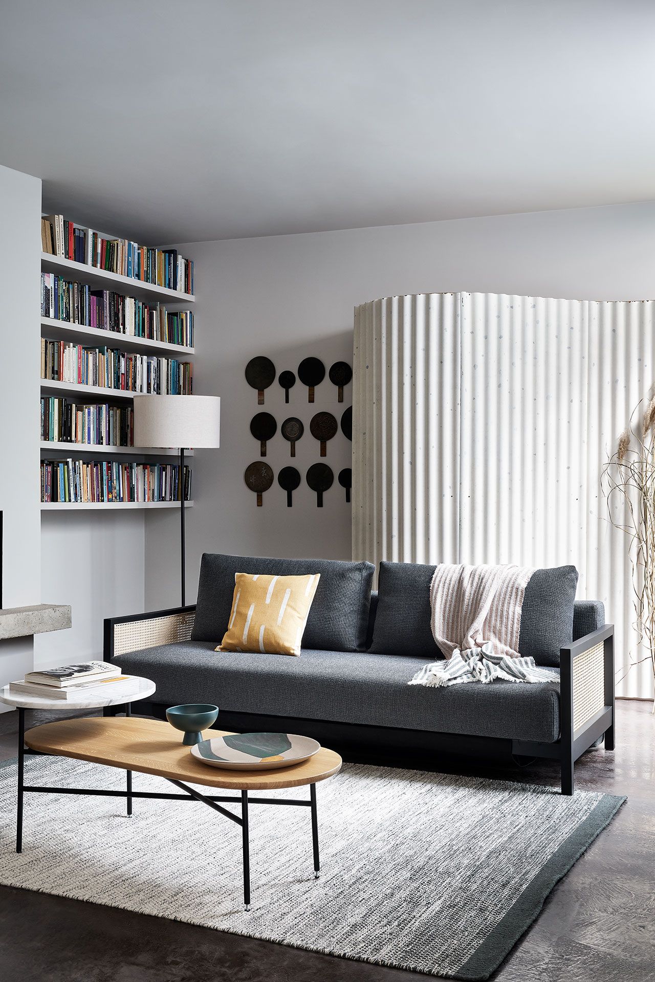 Image may contain Furniture Living Room Indoors Room Couch Table Rug Coffee Table Interior Design and Bookcase