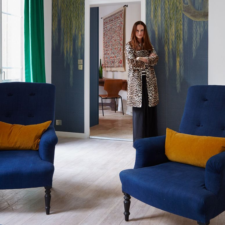 Image may contain: Furniture, Living Room, Room, Indoors, Couch, Human, Person, Armchair, Wood, Flooring, and Home Decor