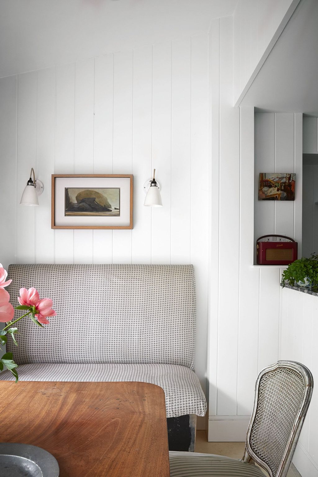 A dining area adjoins the kitchen with a bench for extra seating covered in 'Diamond Dot' a fabric from Lewis Wood and...
