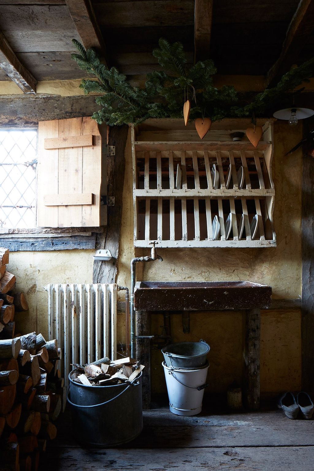 The utility room is used as log storage for the open brick fire.