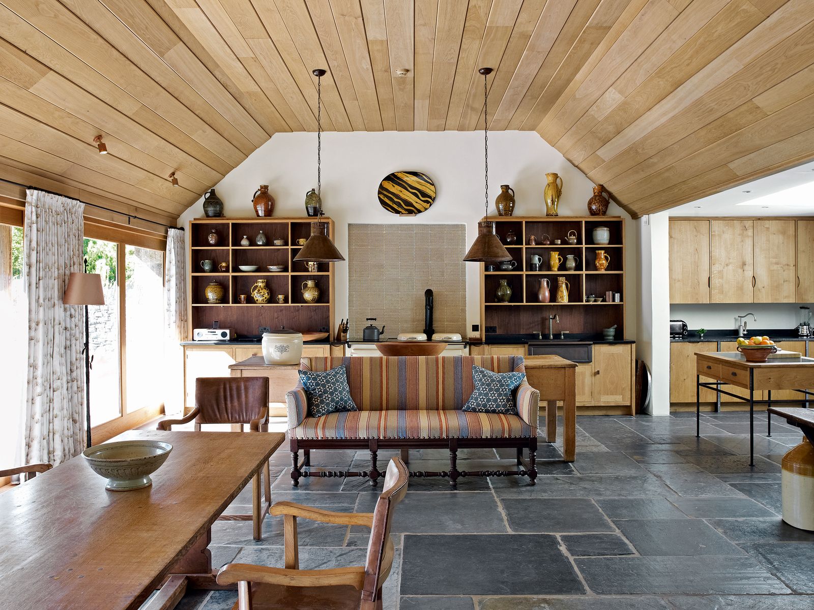 The kitchen is within the new extension. A Mouseman table is flanked by Twenties' Heal's leather chairs and an...
