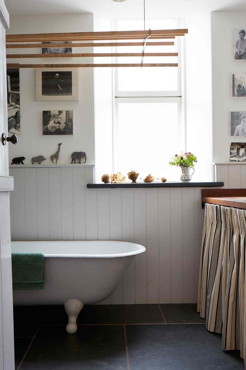 Another bathroom in the house features white panelling and a freestanding bath.