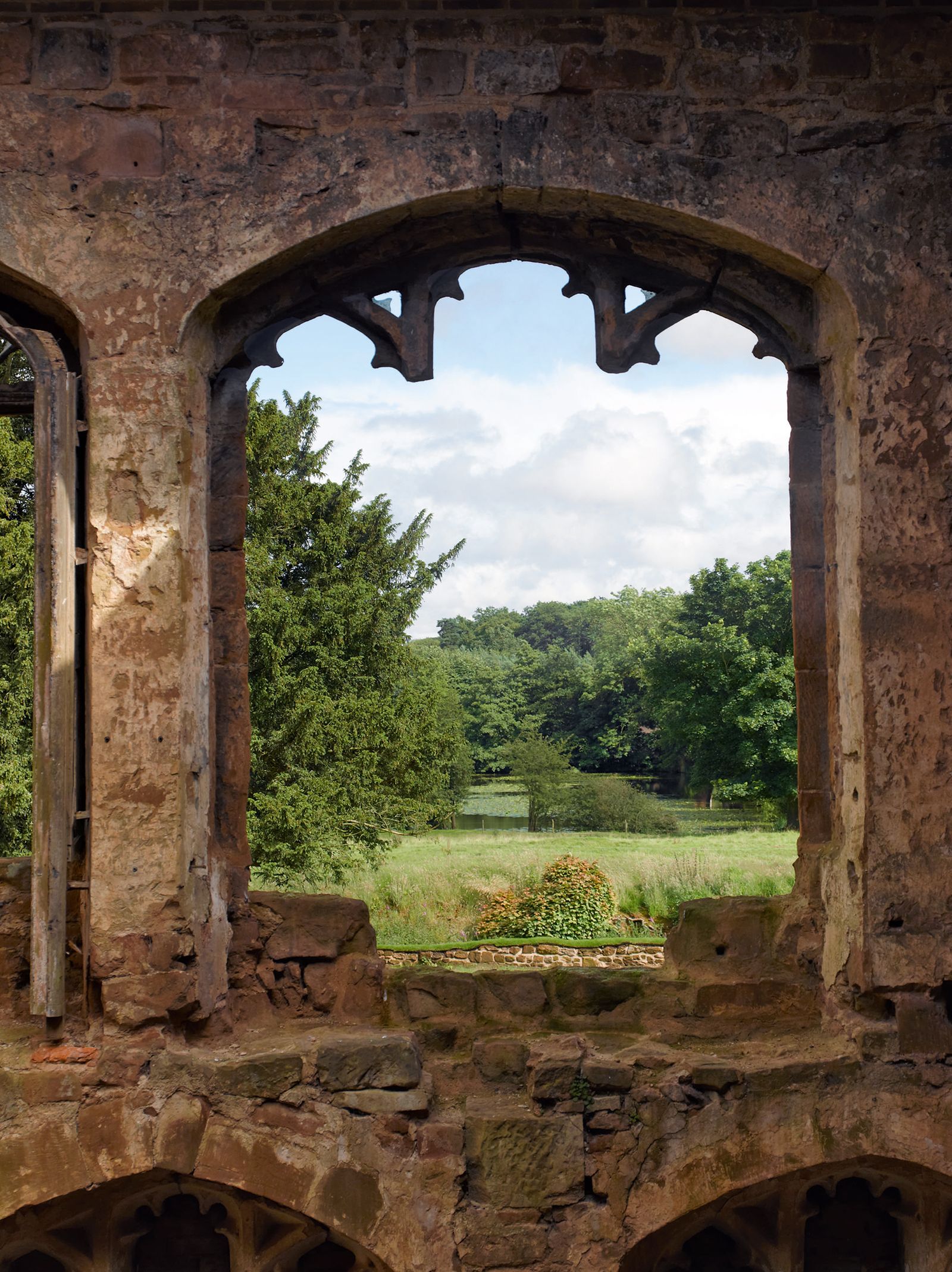 An unglazed window high in the wall which can be seen from the dining area  frames views of the surrounding countryside.
