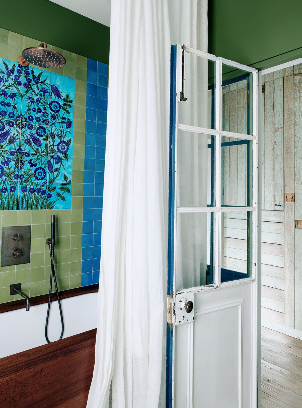 A panel of ‘Faux Iznik tiles framed by zelliges all by Emery Cie line the wall above the bath which has a reclaimed...