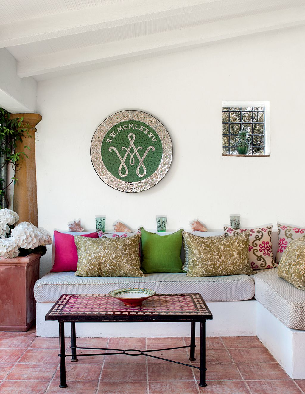 A mosaic roundel commemorating Susan and Harrys 30th wedding anniversary hangs above the outdoor seating area.