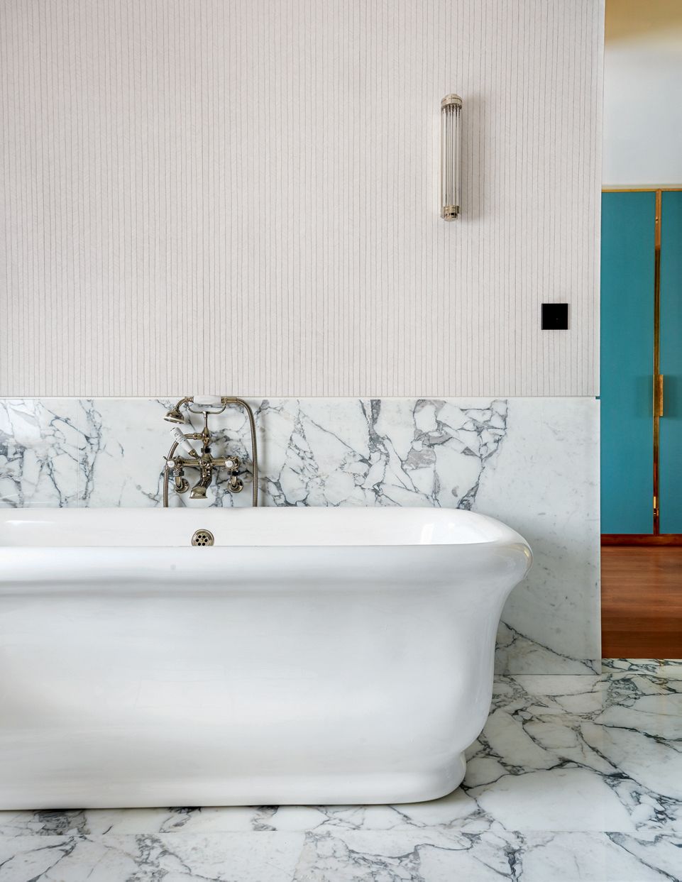 Hermès ‘Herringbone wallpaper in gris ponce complements the Arabascato marble on    the walls and floor. The wall light...