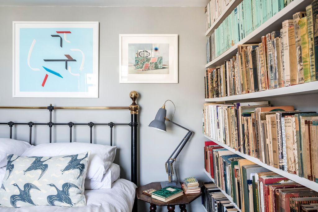 A Toby Paterson screenprint and Louise Bristow gouache hang above Simons bed with cushions in ‘Black Goose    by EQ...