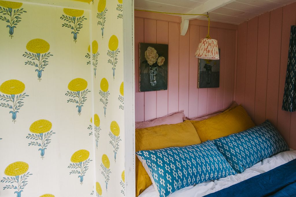 A gathered lampshade in pink 'Dash' cotton hangs over the bed.