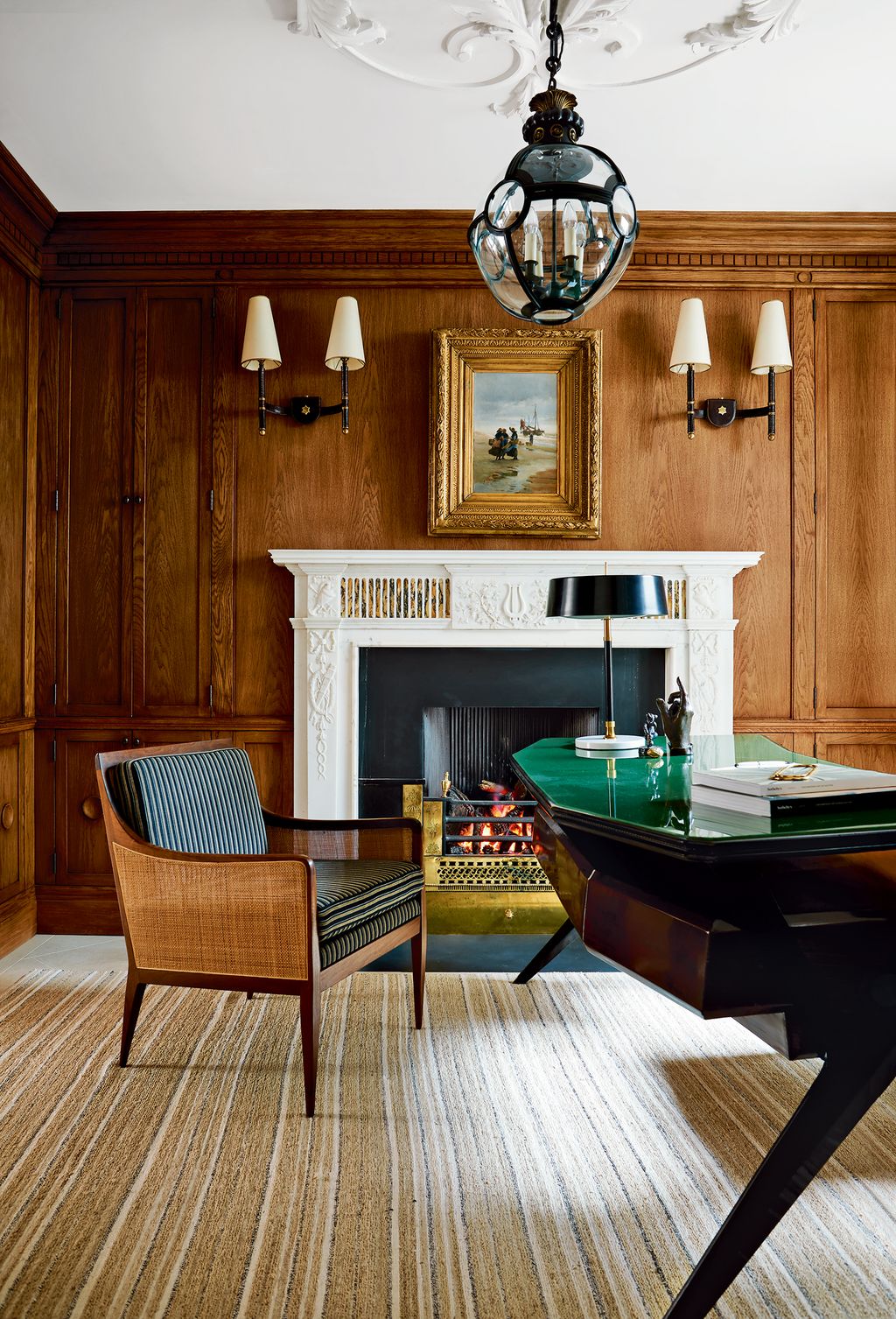 Image may contain Wood Hardwood Flooring Furniture Living Room Room Indoors Table Chair Rug Floor and Fireplace