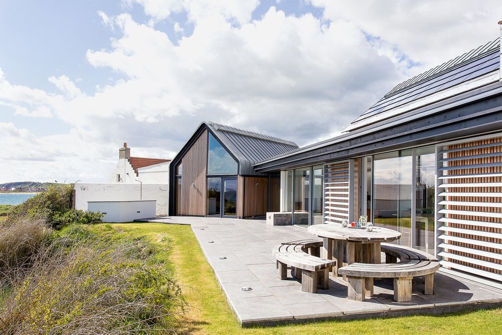 Image may contain Grass Plant Patio Housing Building Porch Cottage and House