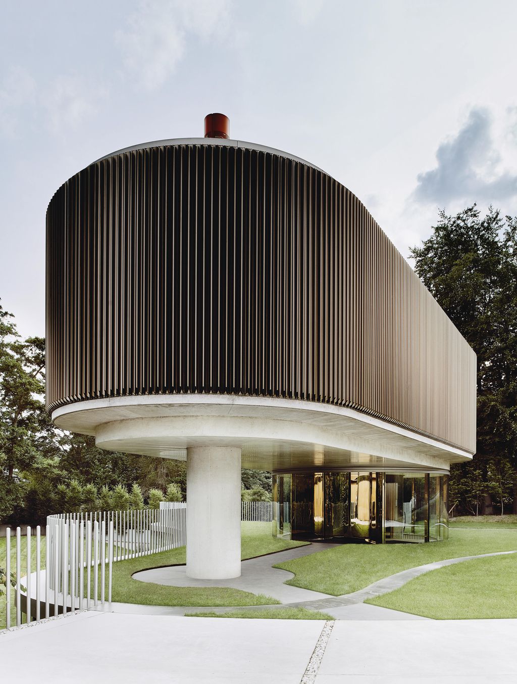 An anodised aluminium screen wraps around the upper storey of the building which houses the main bedroom. The living...