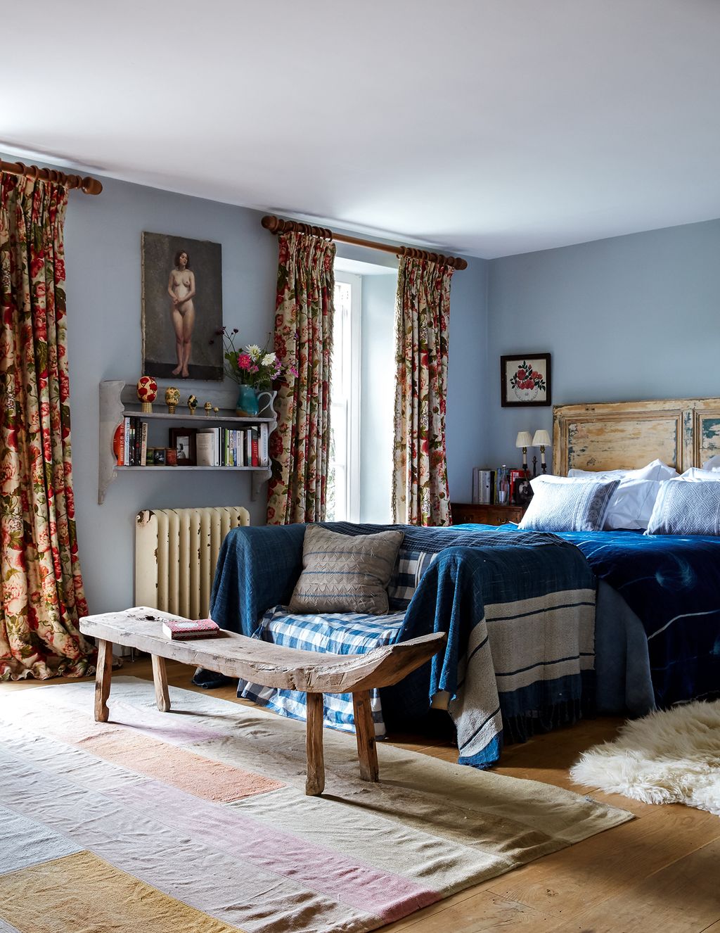 In the main bedroom vintage floral curtains provide an eyecatching focal point among an eclectic mix of finds  from a...