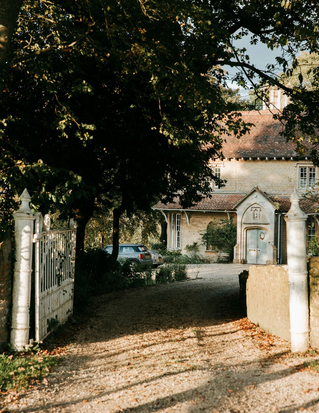 Image may contain Vehicle Transportation Automobile Car Path Gate Tree Plant and Walkway