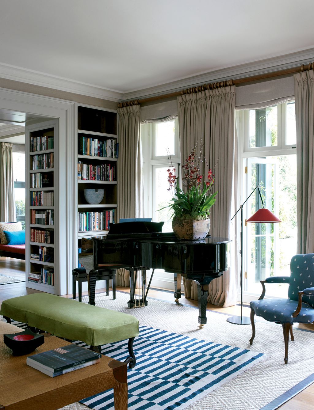 Image may contain Furniture Rug Living Room Indoors Room Bookcase Interior Design Shelf and Chair