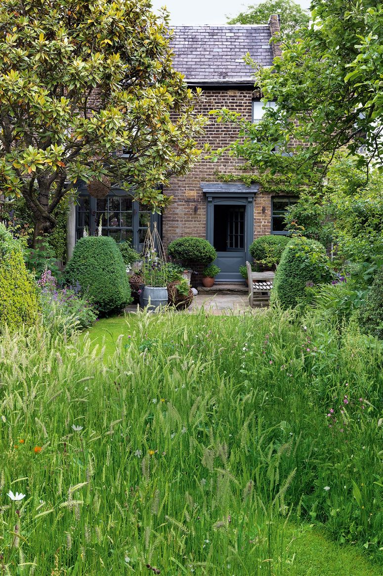 Image may contain: Outdoors, Garden, Arbour, Grass, Plant, Cottage, Housing, House, Building, Vase, Pottery, and Potted Plant