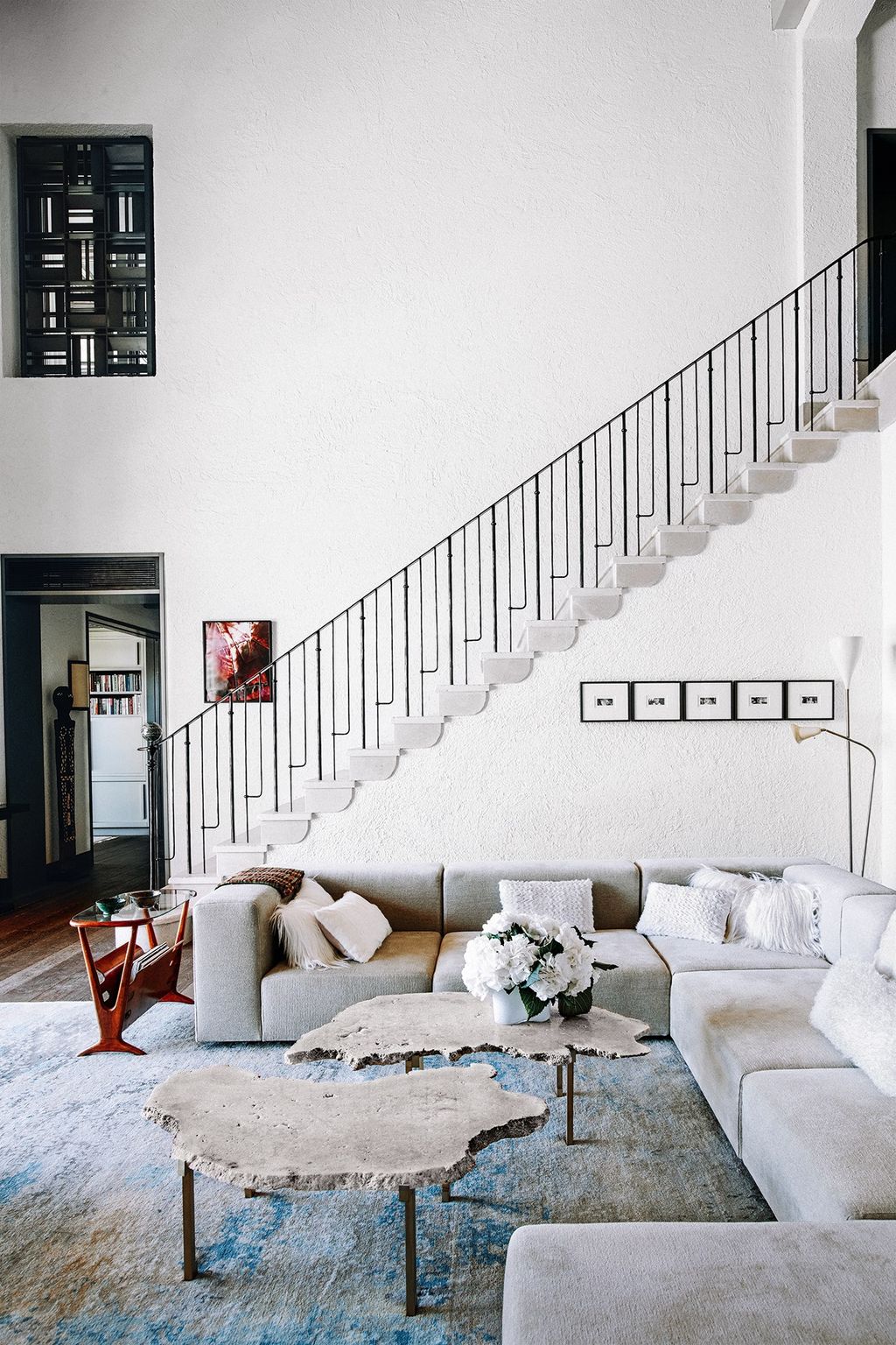 Image may contain Living Room Room Indoors Furniture Staircase Couch Interior Design Table Rug and Coffee Table