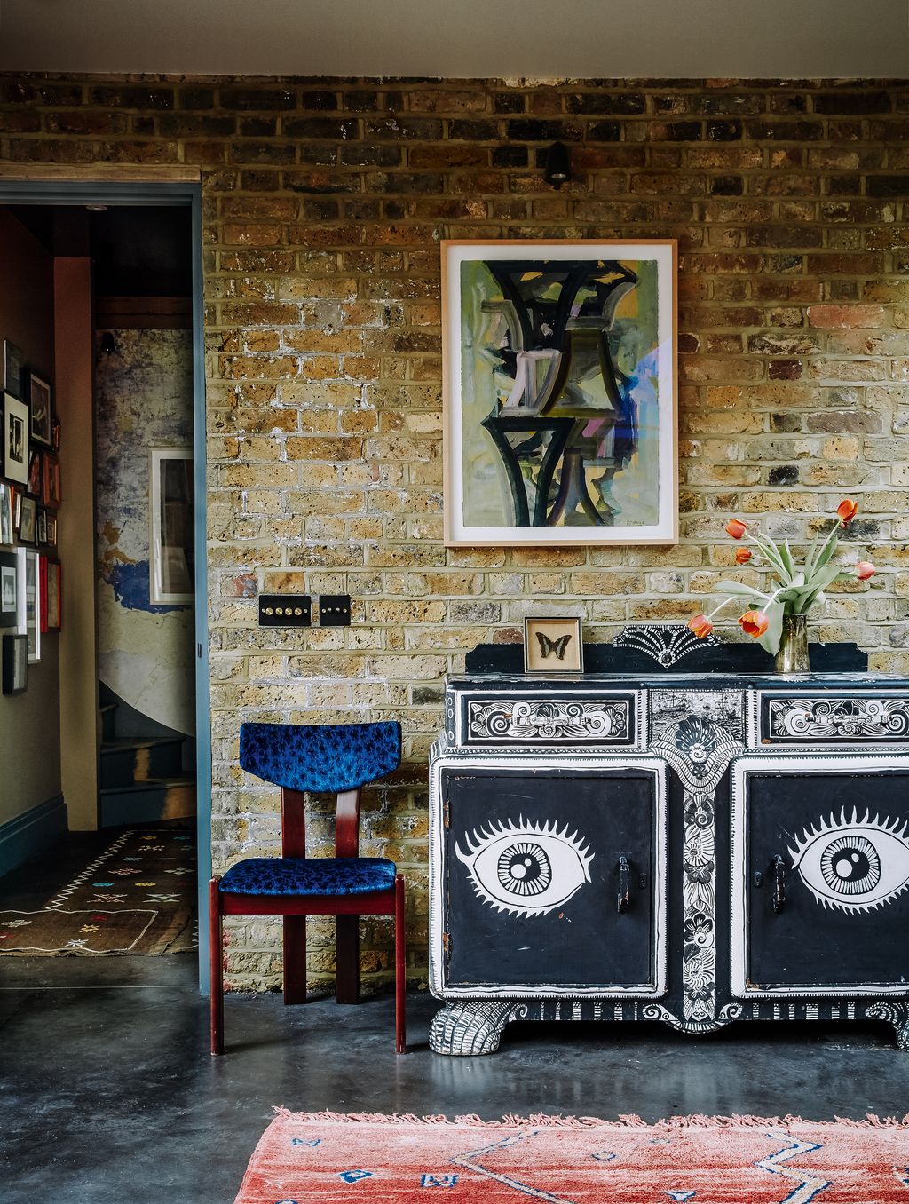 A watercolour by Donald Kaufman hangs above a Forties sideboard handprinted with a striking monochrome design by the art...