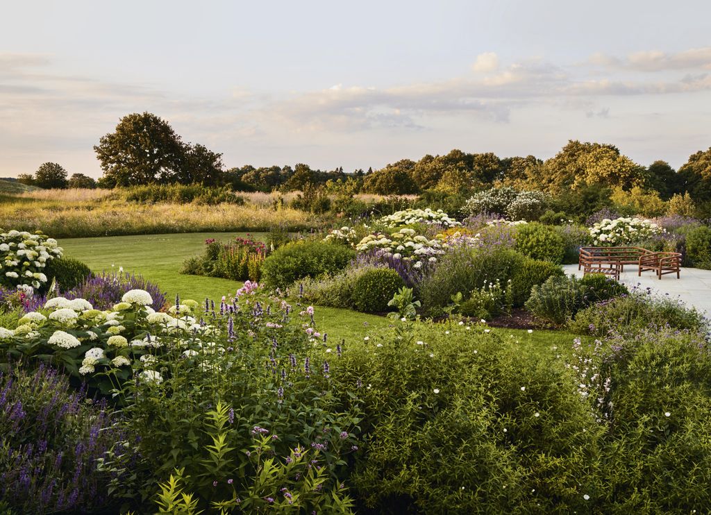 The owners specified there should be no straight lines in the garden so the limestone terrace extends out into the...