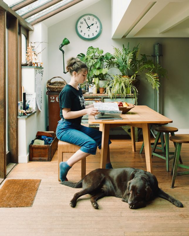 Image may contain Human Person Animal Pet Canine Dog Mammal Furniture Wood Flooring Table and Architecture