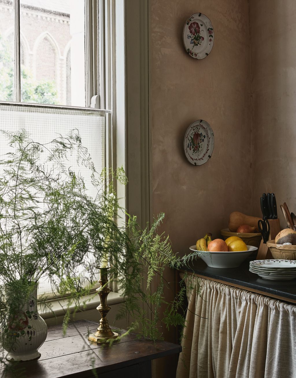 Curtained shelves provide storage below the granite kitchen countertop.