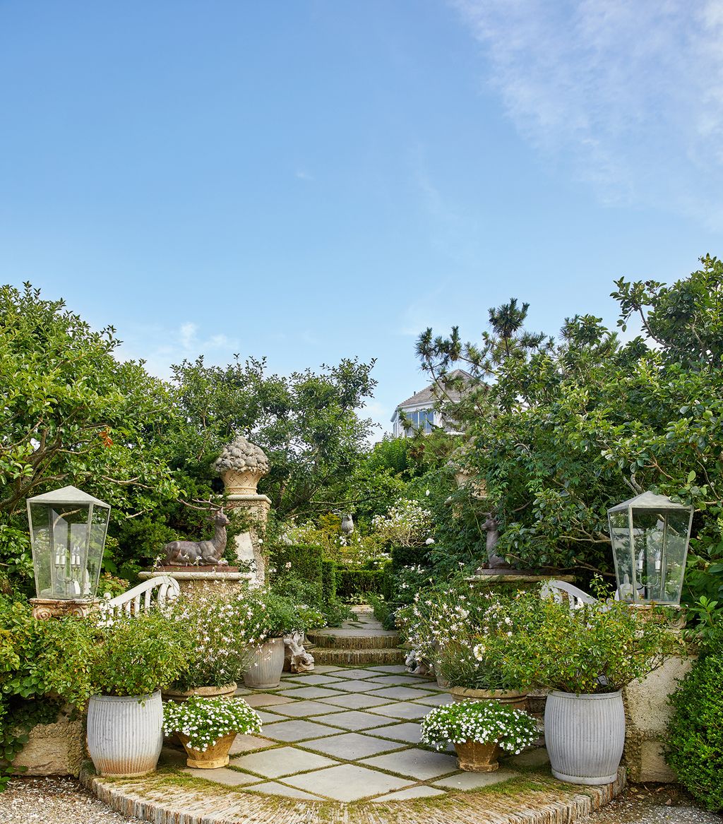 The entrance to the property is flanked by stag statuary and white flowering plants in urns a nod to the White Garden at...