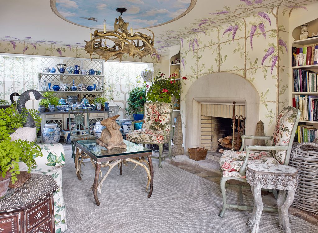 In the groundfloor potting room its walls exuberantly painted with botanical motifs a stone goat rests on a coffee table...