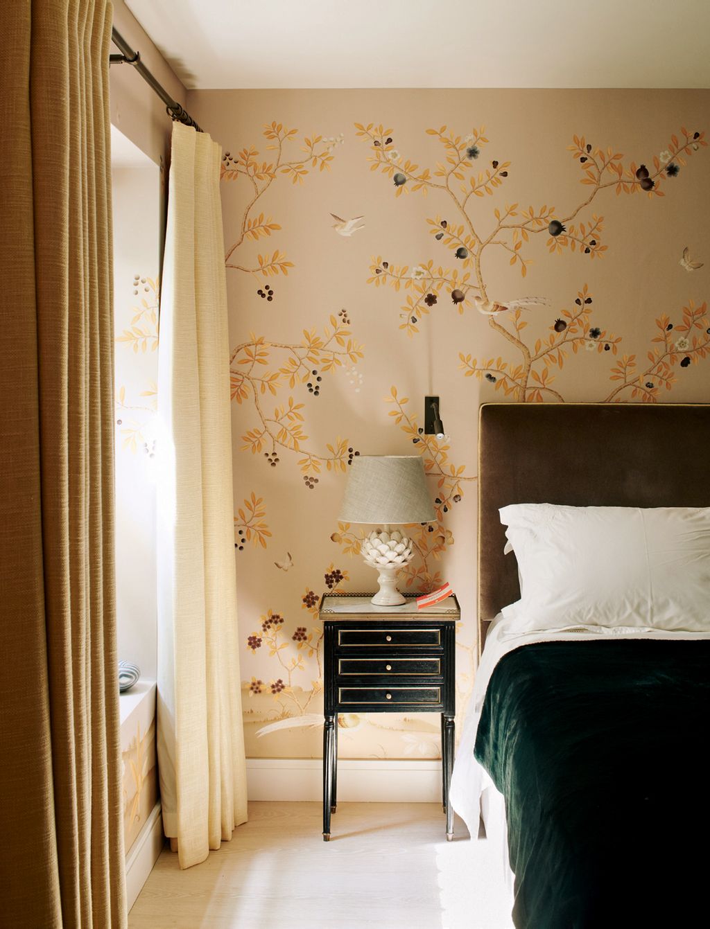 An emerald green velvet throw picks up on the accents of Fromentals ‘Florent wallpaper. The bedside table is from...