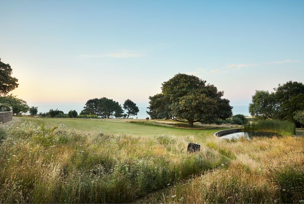 The garden in front of the house was kept open and simple so as not to compete with the sea views. An existing pond was...