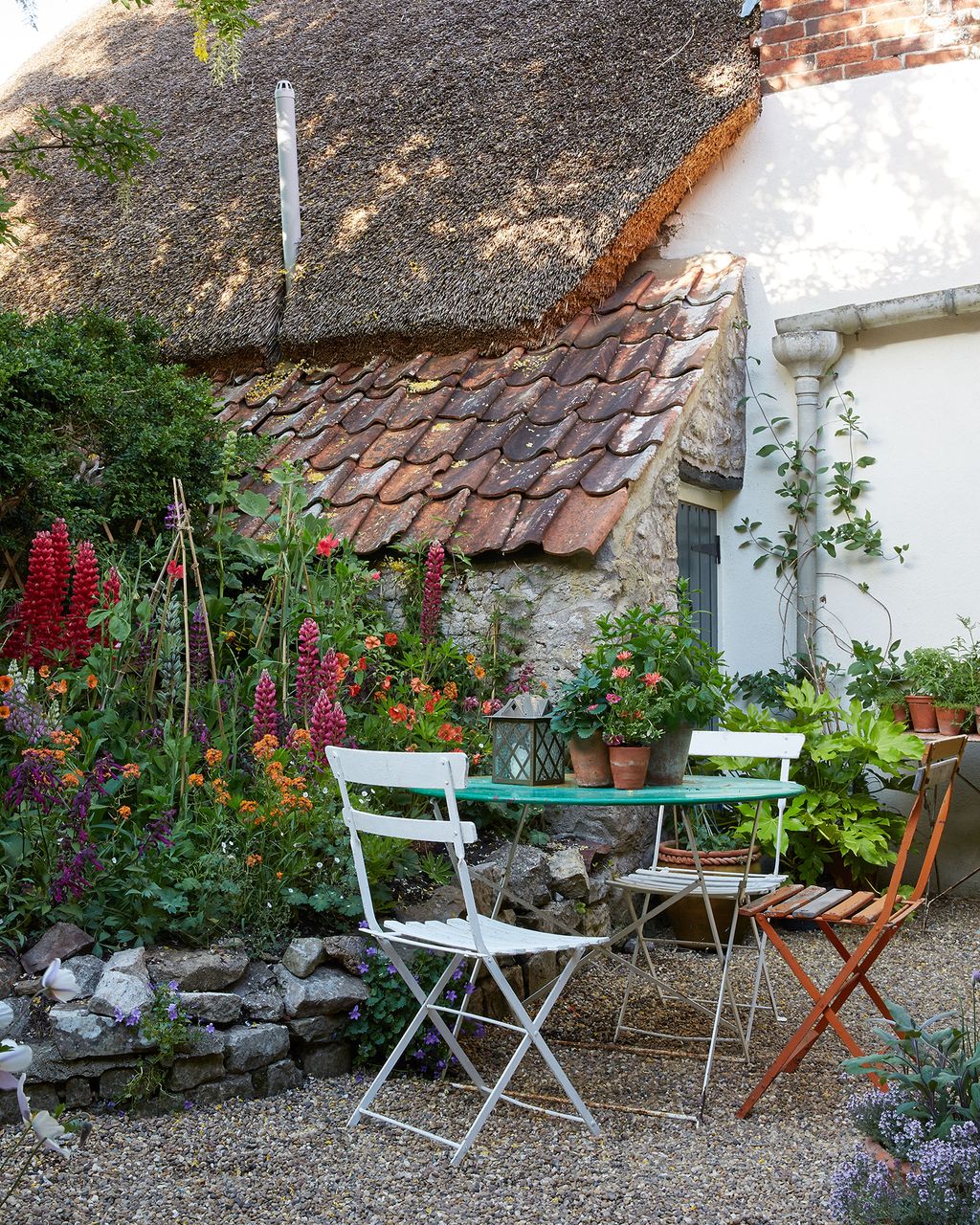 Image may contain Furniture Chair Outdoors Cottage Housing House Building Roof Vase Plant and Pottery