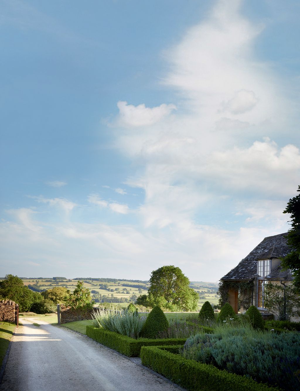 Between the drive and the kitchen a formal herb garden of boxedged beds encloses yew topiary and a profusion of herbs.