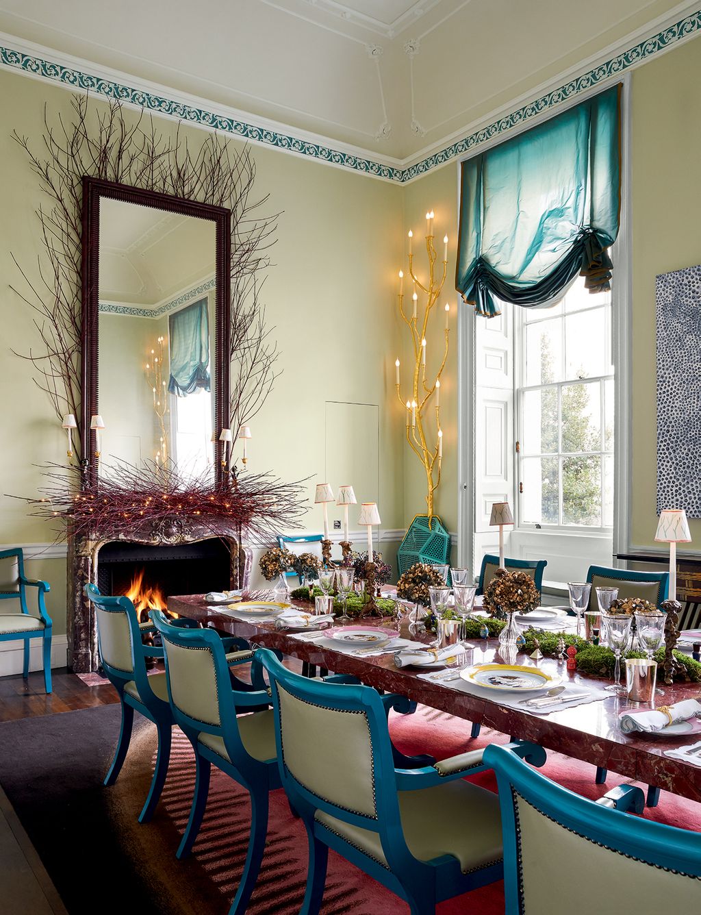 The red tones of the Cornus sericea twigs decorating the mirror pick up on the rug and marbletopped table both by Mattia...