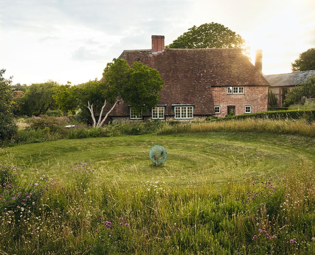 A Simon Thomas sculpture sits in the sunken spiral at the back of the house.
