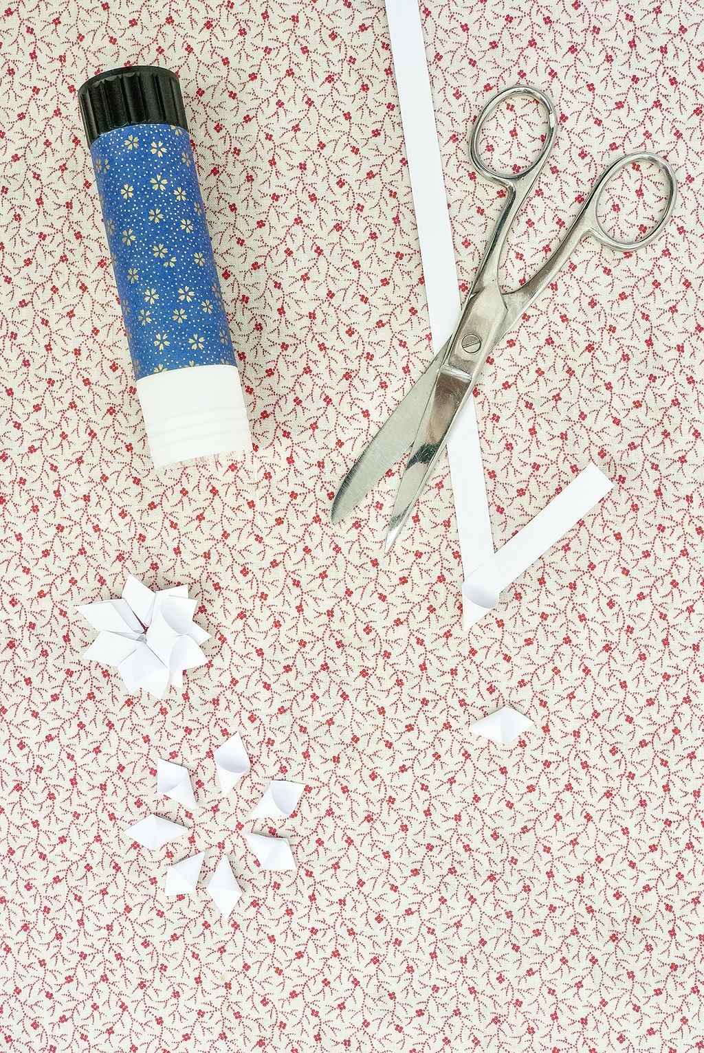 1. Take one of your strips and bend a section into a small cone shape with the two ends of the paper crossing at the...