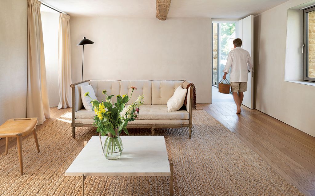 Image may contain Flooring Human Person Furniture Living Room Room Indoors Home Decor Wood Table Floor and Couch