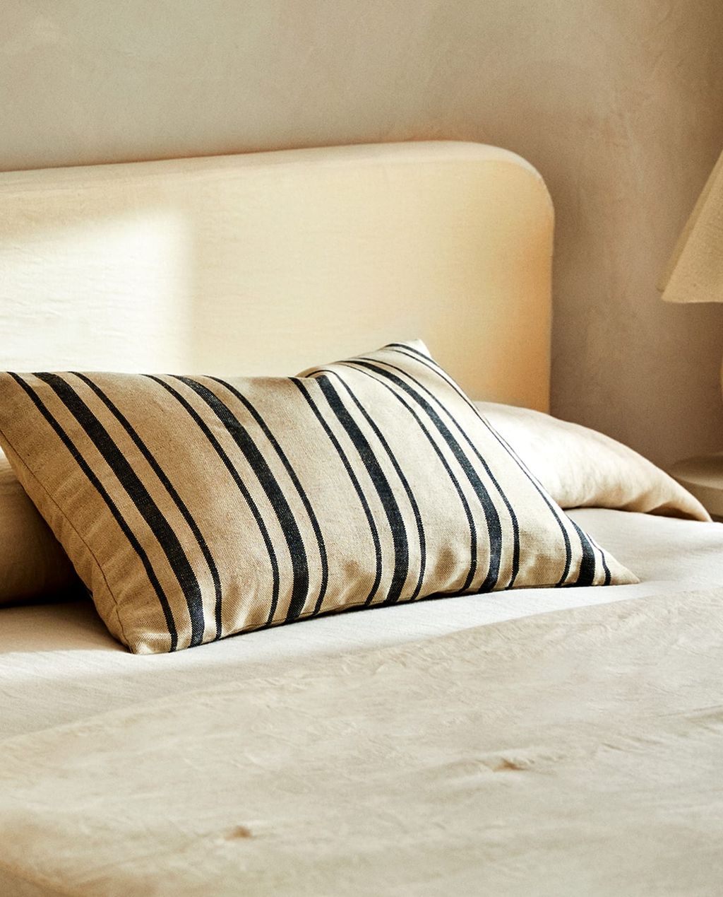 Image may contain Cushion Pillow Couch Furniture Lamp and Table Lamp