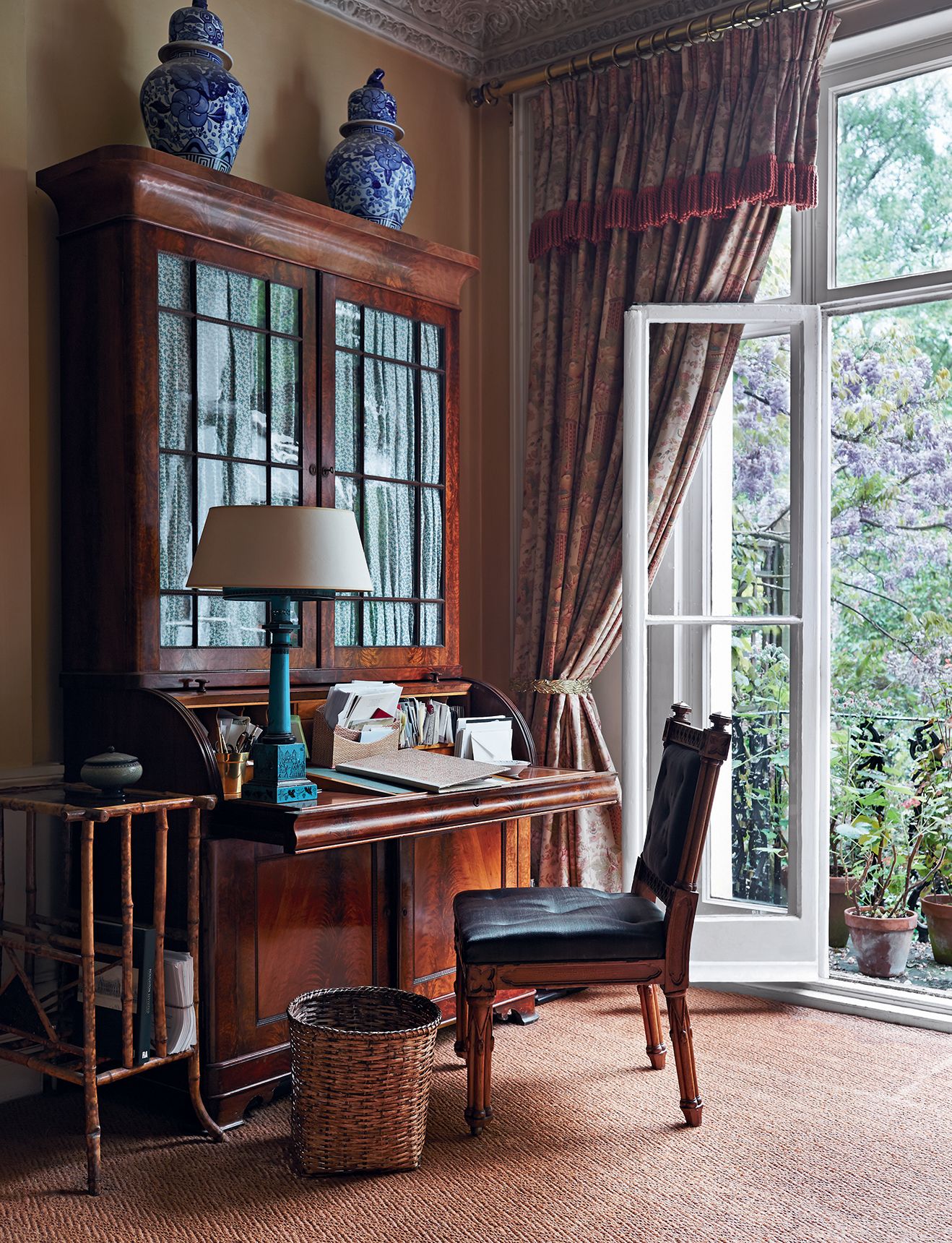 In the drawing room a Victorian rolltop desk stands by the french window.