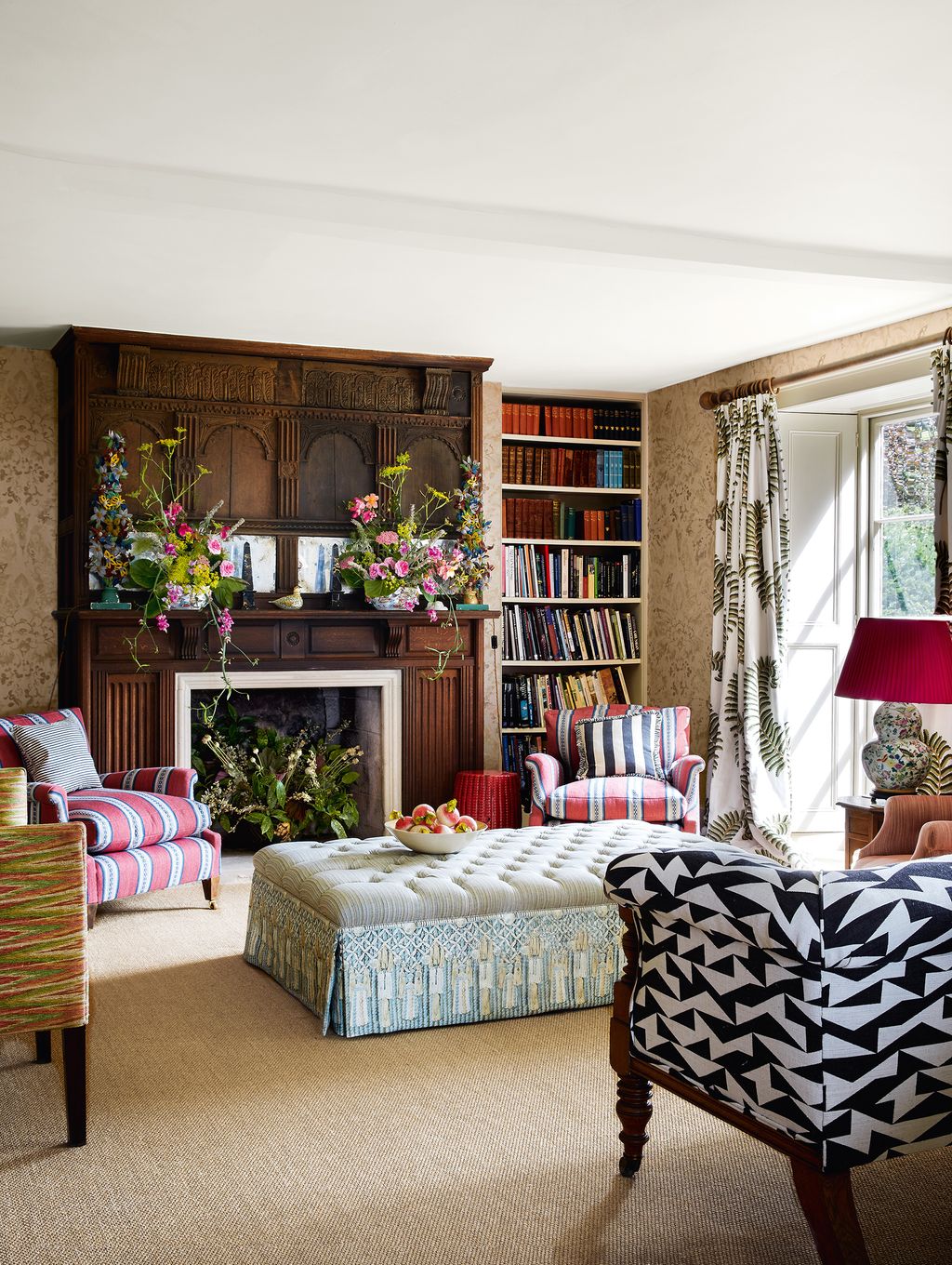 On either side of the chimneypiece which was moved from a local farmhouse in the early 20th century are armchairs...