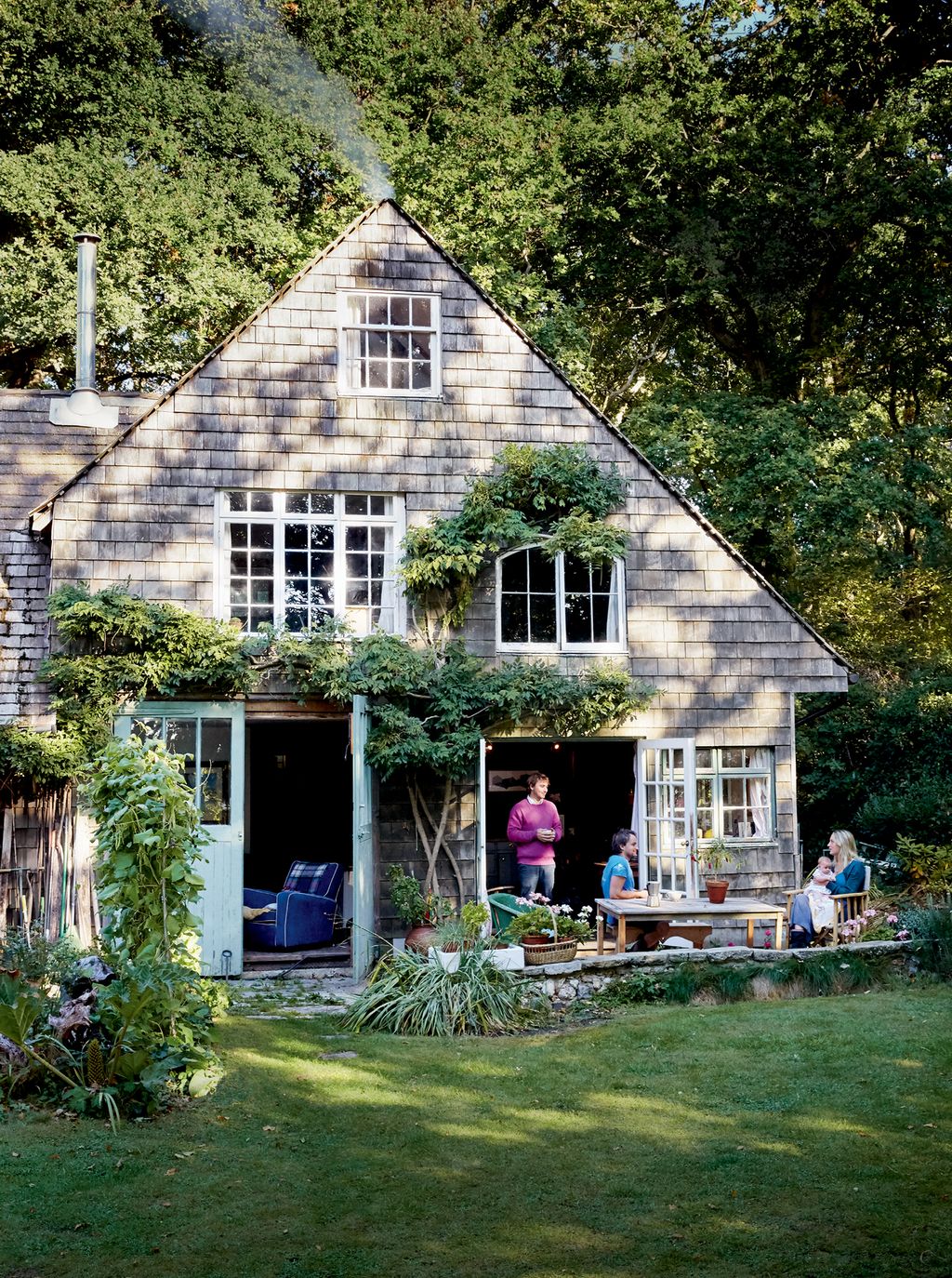 Image may contain House Cottage Housing Building Human Person Plant Outdoors Bush Vegetation Villa and Grass