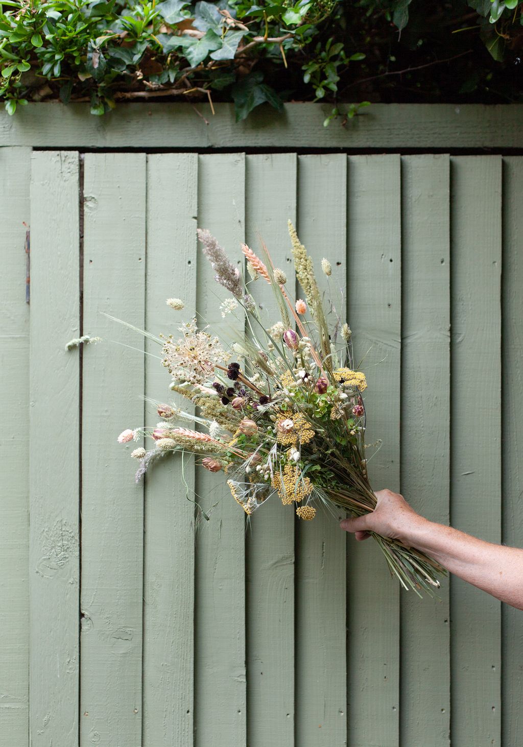 Image may contain Plant Human Person Flower Flower Bouquet Flower Arrangement Blossom Ornament Vase and Pottery