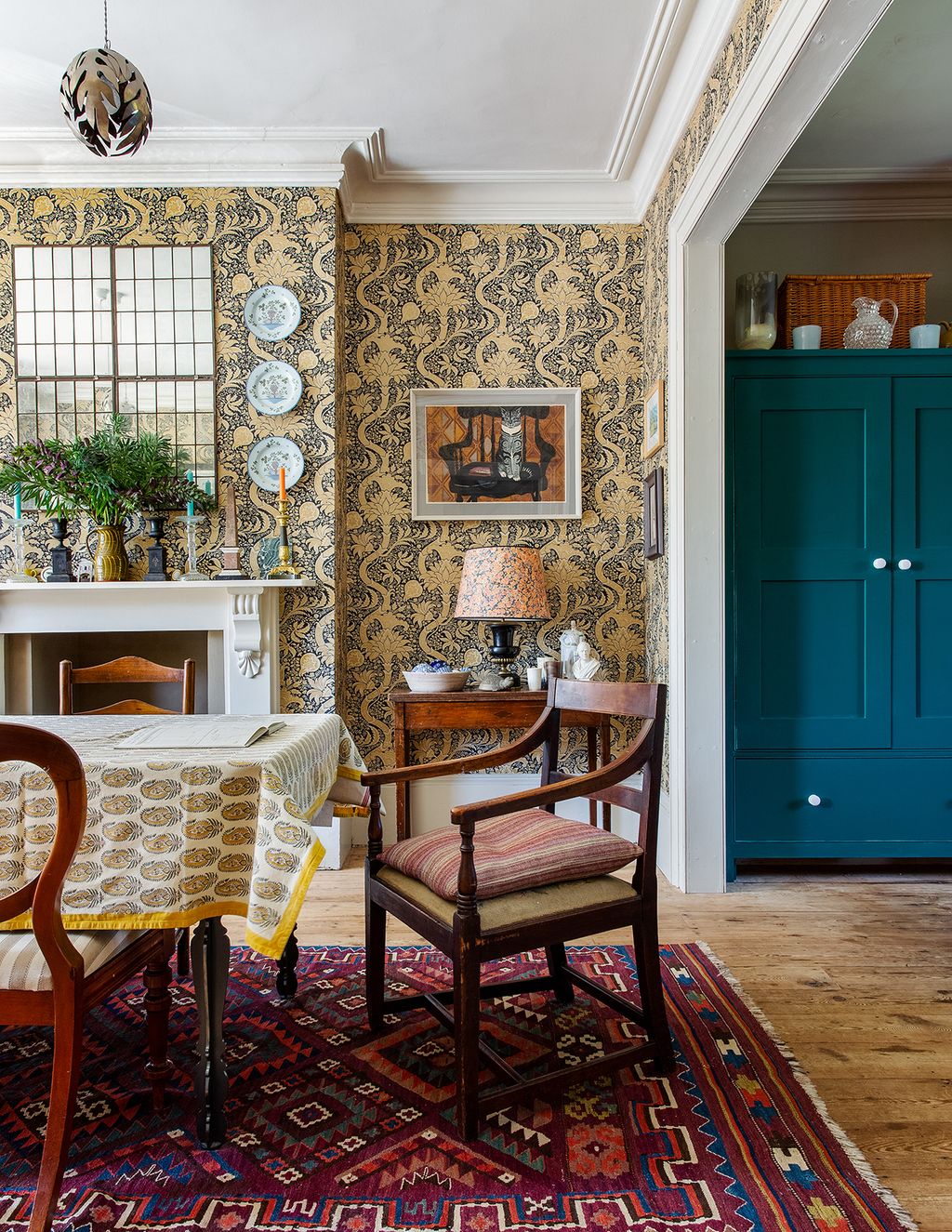 In the dining room the wallpaper is Morris  Co's 'Indian' pattern. English Delftware plates are arranged over the...