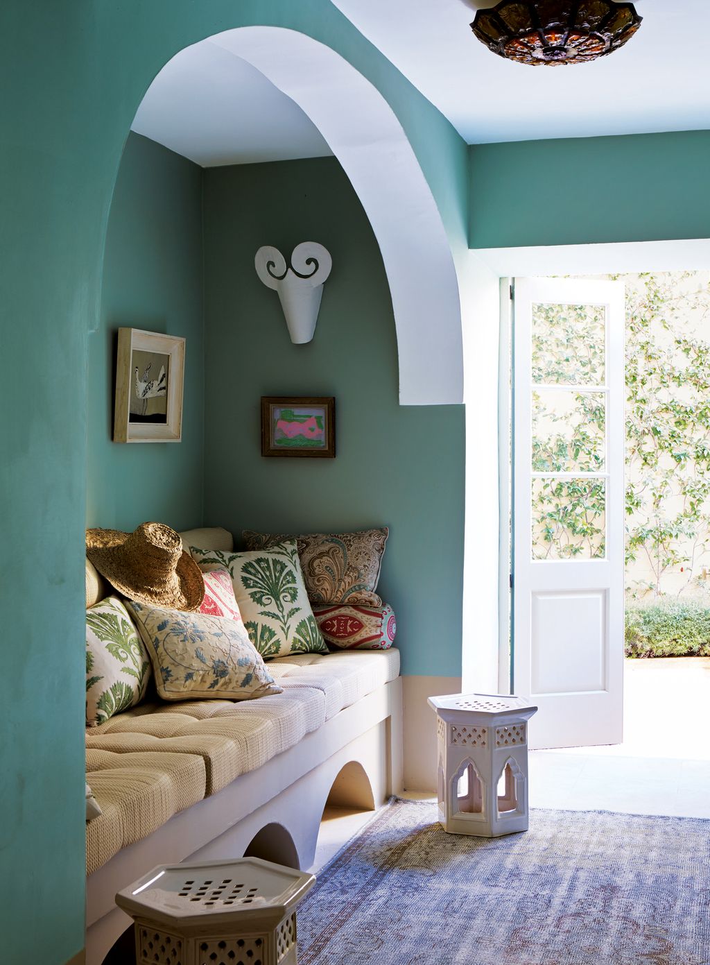 In the adjoining television room a banquette bench and cushions covered in fabric by Robert Kime and Manuel Canovas...