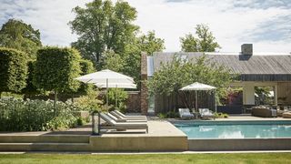 Image may contain Patio Grass Plant Outdoors Furniture Bench Pool Water and Building